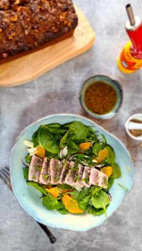 Gut Healthy salad recipe - seared tuna salad with spinach fennel and orange on a table with orange fennel dressing an date loaf