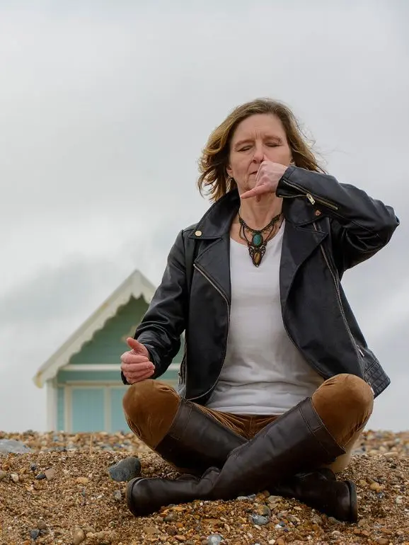 Nikkie Windsor leading a breathwork session on the beach, demonstrating stress management techniques.