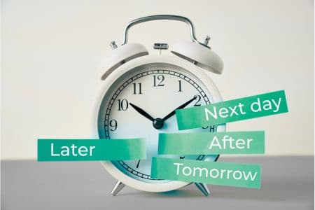 An old-style alarm clock surrounded by labels reading “later,” “after,” “next day,” and “tomorrow” — illustrating delayed food sensitivity reactions that can cause bloating beyond immediate food responses.